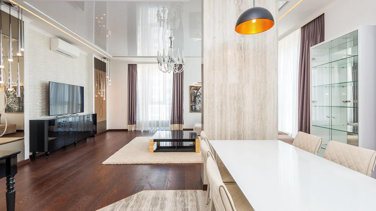 Pristine dining and living room with designer lighting